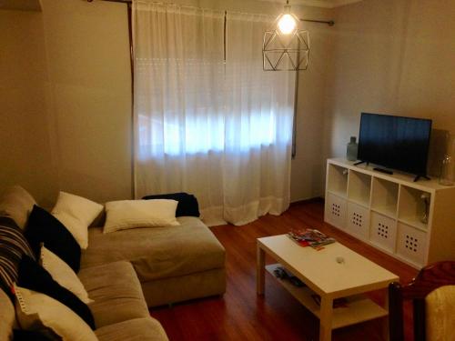 a living room with a couch and a tv at Póvoa City Center Apartment in Póvoa de Varzim