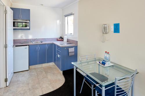 a kitchen with a table and a sink at Livingston Motel in Whakatane