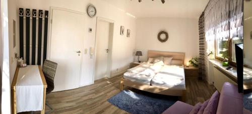 ein Schlafzimmer mit einem Bett und einem Sofa in einem Zimmer in der Unterkunft Apartment am Stadtpark in Neumarkt in der Oberpfalz