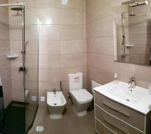 a bathroom with a toilet and a sink and a shower at Glory Holiday Rooms in Lagos