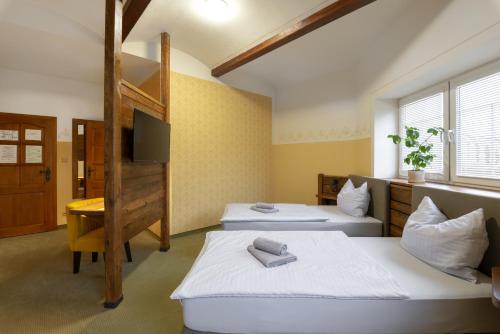 カルロヴィ・ヴァリにあるHotel U Simlaのベッド2台と二段ベッド1組が備わる客室です。