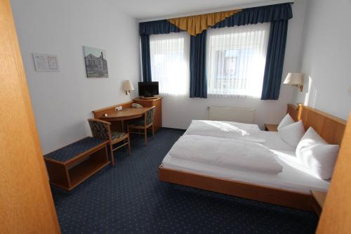 a hotel room with a bed and a desk at Hotel Schoch, Trossingen in Trossingen