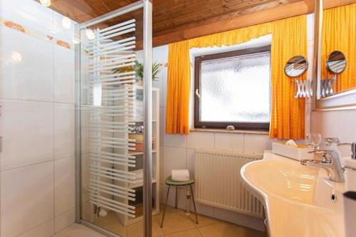 y baño con ducha y lavamanos. en Ferienhaus Hohe Tauern in Piesendorf, en Piesendorf