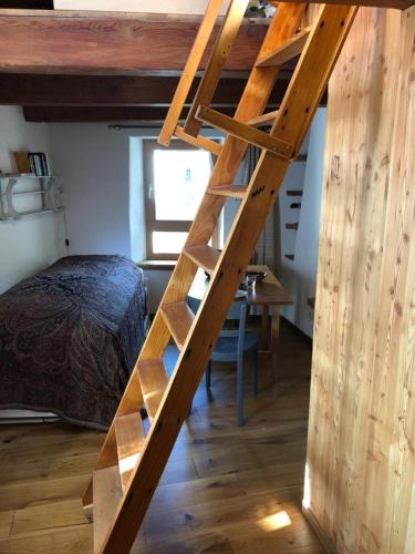 a wooden ladder in a bedroom with a bed at Rustico Cadrobi 20 in San Vittore