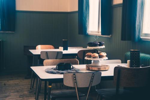 a room with tables and chairs with cakes on them at The Mangevie in Furudal