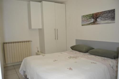 a bedroom with a white bed with green pillows at Poggio ai Vigneti in Entratico