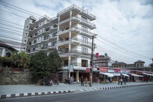 a large white building on the side of a street at Hotel Himalayan Vacation in Pokhara