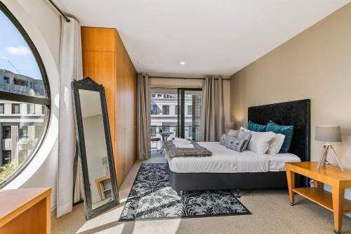 a bedroom with a large bed and a mirror at Enormous One Bedroom Beauty in CBD! Free Parking in Auckland