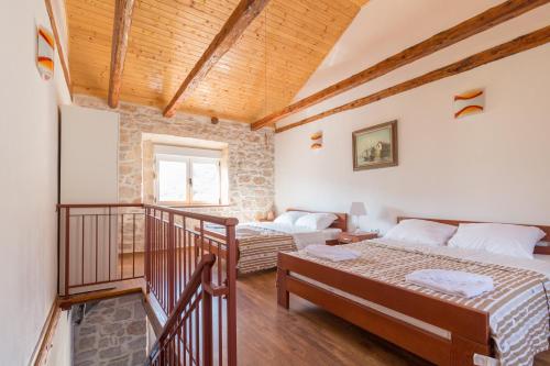 a bedroom with two beds and a staircase in a building at Apartment Janet in Luka