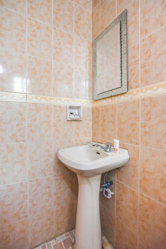 a bathroom with a sink and a mirror at La Gracia Apartelle in Tagaytay