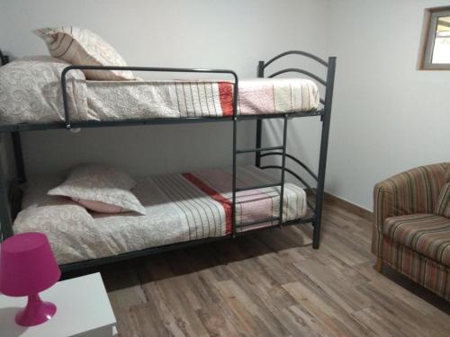 sypialnia z 2 łóżkami piętrowymi i kanapą w obiekcie la Casita w mieście Carmona