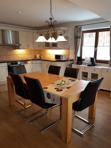uma cozinha com uma mesa de madeira com cadeiras à volta em Allgäuer Landhaus em Fischen