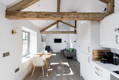 a kitchen and dining room with white walls and wooden beams at The Old Granary in Barnetby le Wold