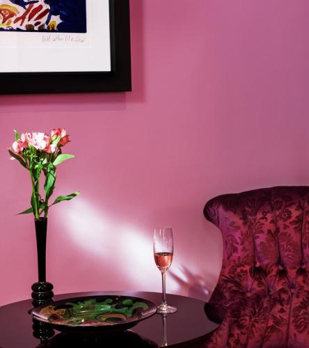 a table with a vase of flowers and a glass of wine at Dorsia Hotel & Restaurant in Gothenburg
