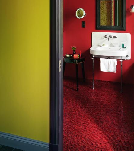 a bathroom with a white sink and a red wall at Dorsia Hotel & Restaurant in Gothenburg