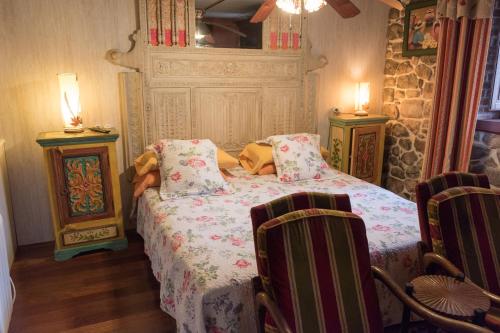 a bedroom with a bed and two chairs at Luna del Valle in Nueva de Llanes