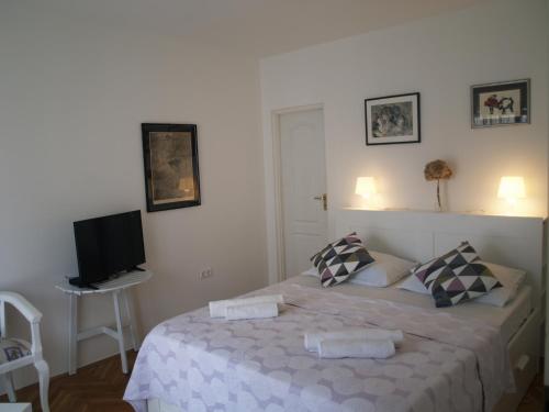a bedroom with a bed with a tv on the wall at Apartment Ilko in Dubrovnik