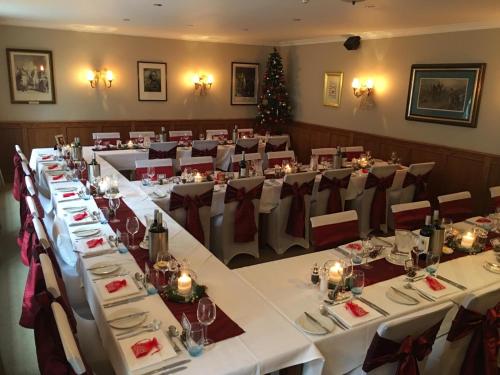a conference room with white tables and chairs and a christmas tree at Royal Hotel in Deal