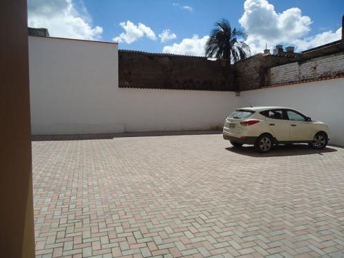 a car parked in a parking lot next to a wall at Alejandrina Hotel in Cuenca