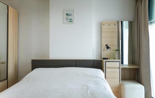 a bedroom with a white bed and a window at Bangkok Feliz Sukumvit69 in Bangkok
