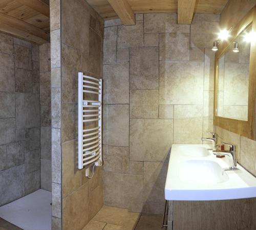 uma casa de banho com um lavatório e um espelho em Le Refuge em Cordon