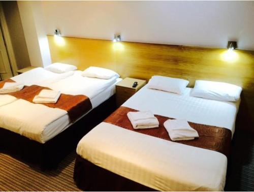 Habitación de hotel con 2 camas y toallas. en West Cromwell Hotel, en Londres