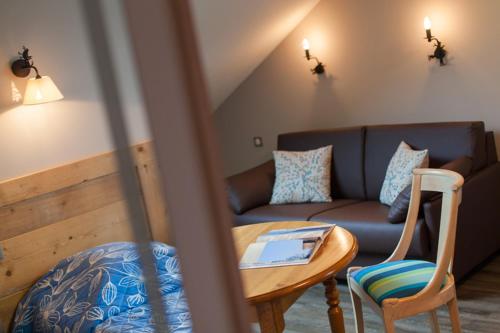a living room with a couch and a table at le bon accueil in Malbuisson