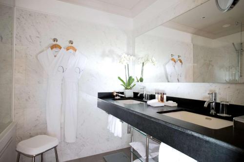a bathroom with a black counter and a sink and mirrors at La Villa Calvi in Calvi