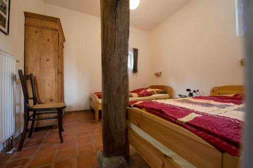a bedroom with a bed and a chair in it at Hürhus Hude in Hude