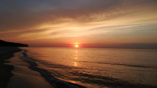 a sunset over the ocean with the sun setting at Willa Wiselka in Wisełka