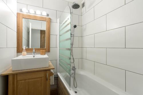 een witte badkamer met een wastafel en een douche bij Apartment Grepon 3A in Chamonix-Mont-Blanc
