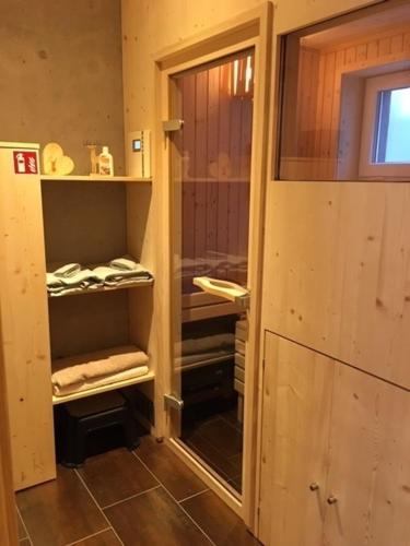 uma casa de banho com uma porta de vidro para um armário com toalhas em Chalet Breitnauschön em Breitnau