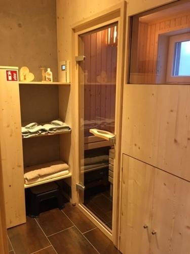 a bathroom with a glass door to a closet with towels at Chalet Breitnauschön in Breitnau