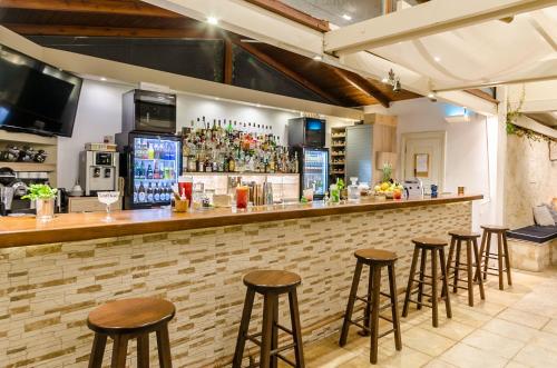 a bar with stools in a room with a counter at Pela Mare Hotel in Agia Pelagia