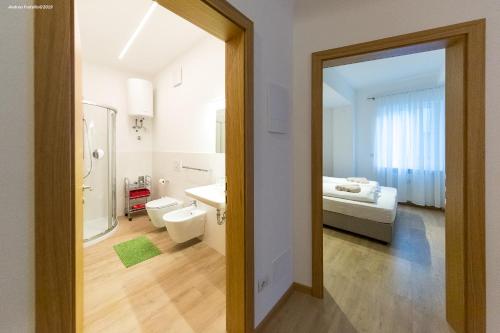 bagno con servizi igienici, lavandino e specchio di City Charme Apartments a Bolzano