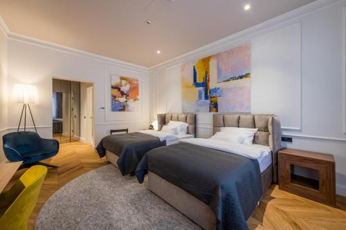 a hotel room with two beds and a chair at Boutique hotel Tvrđa in Osijek