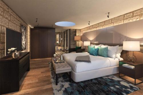 a bedroom with a large bed and a living room at Mizpe Hayamim by Isrotel Exclusive in Rosh Pinna