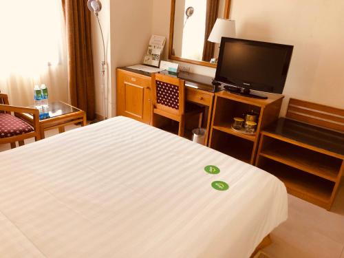ein Hotelzimmer mit einem Bett und einem Flachbild-TV in der Unterkunft Hotel Al Madinah Holiday in Muscat