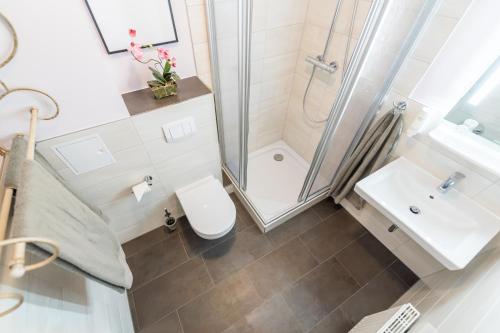 a bathroom with a shower and a toilet and a sink at Hotel Villa Waldfrieden in Ostseebad Sellin