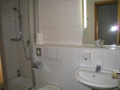 a bathroom with a shower and a sink and a toilet at Posthotel Hans Sacks in Montabaur