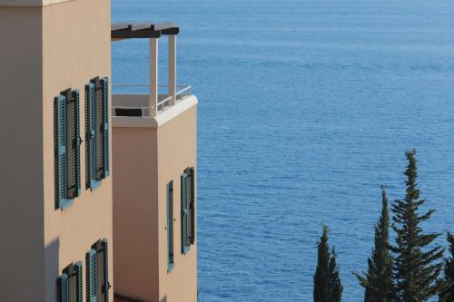 a building with the ocean in the background at Sun Gardens Dubrovnik in Dubrovnik