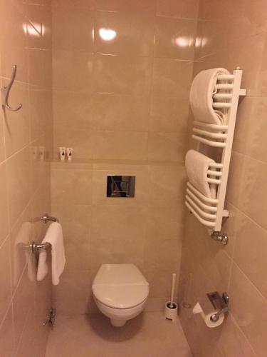 a bathroom with a toilet and a shower with towels at Camping Motel WOK in Warsaw