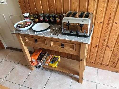 a table with a toaster on top of it at Dearg Mullach Self Contained B&B in Uig