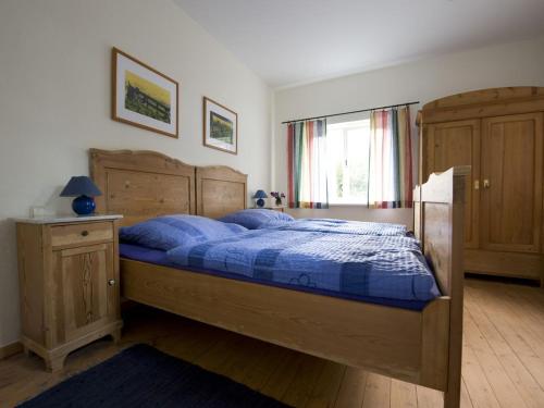 a bedroom with a wooden bed with a blue comforter at Auf dem Berg Hude in Hude