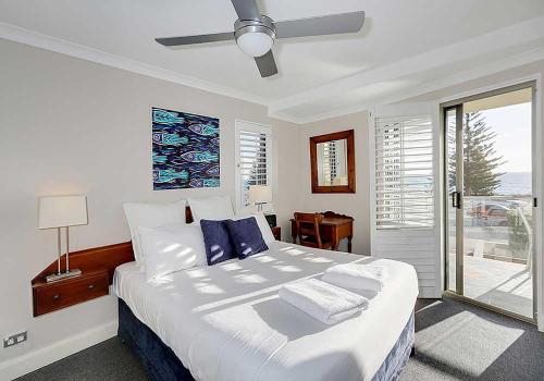 a bedroom with a large bed with blue pillows at Salty Kiss in Perth