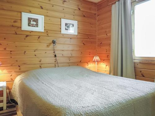 a bedroom with a bed in a wooden wall at Holiday Home Laulelevi by Interhome in Levi