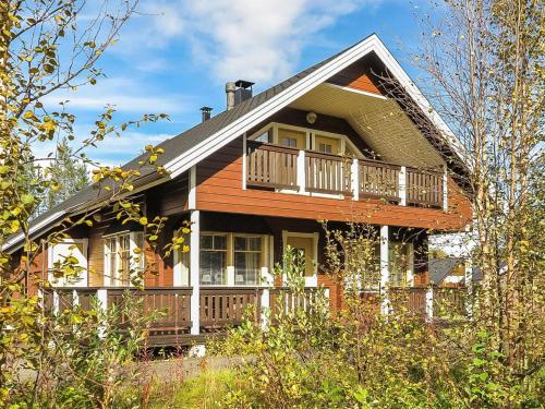 a wooden house with a porch and a balcony at Holiday Home Laulelevi by Interhome in Levi
