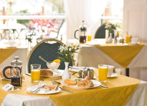 a table topped with plates of food and orange juice at Tor Dean Guest House in Torquay