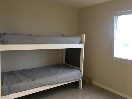 a bedroom with two bunk beds and a window at AYRES DEL MAR de Cobo in Mar de Cobo