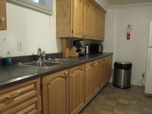 a kitchen with wooden cabinets and a sink at Comerford's Ocean View Suites in Holyrood